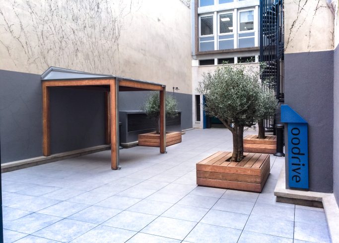 Patio extérieur aménagé avec olivier et assises intégrées