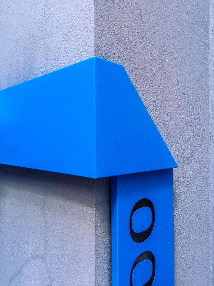 Détail de signalétique bleue sur la façade